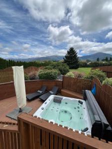 a hot tub on top of a deck with a view at Vibrant Living Retreat in Hanmer Springs