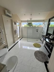 a bathroom with two sinks and a glass shower at Vibrant Living Retreat in Hanmer Springs