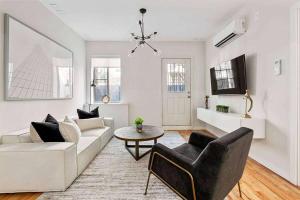 una sala de estar con un sofá y una mesa en Luxury 3BR Duplex w Private Patio in Upper East, en Nueva York