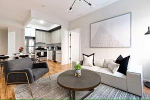 una sala de estar con un sofá y una mesa en Luxury 3BR Duplex w Private Patio in Upper East, en Nueva York