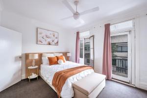 een witte slaapkamer met een bed en een raam bij 3BR CBD Aircon Redfern family home in Sydney
