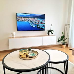 Una sala de estar con un televisor en la pared. en Apartman KOMFORT 33, en Donje Mladice 31 fotos más