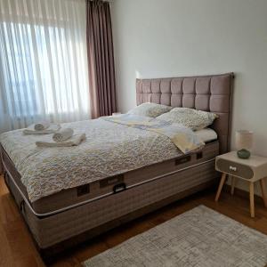 a bedroom with a large bed with a large window at Apartman KOMFORT 33, Near Sarajevo Airport & Free Parking in Donje Mladice