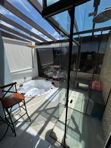 a balcony with a hot tub and a chair at Chale Bella Vista in Venda Nova do Imigrante +10 photos