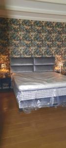 een bed in een slaapkamer met een bloemenmuur bij Noardlik B&B in Birdaard