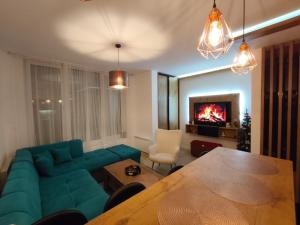 a living room with a green couch and a table at Hena, Free Parking Included in Bjelašnica