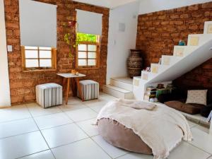 a bedroom with white tile flooring and a brick wall at Casa de Adobe in Lençóis +18 photos
