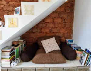 a book shelf under the stairs with a couch and books at Casa de Adobe in Lençóis