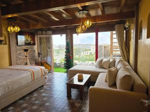 uma sala de estar com um sofá e uma cama em Rooftop studio with ocean view em Essaouira