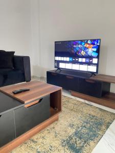 a living room with a couch and a flat screen tv at Central Park hotel apartment in Madinaty +8 photos