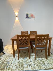 a dining room table and two chairs on a rug at Central Park hotel apartment in Madinaty