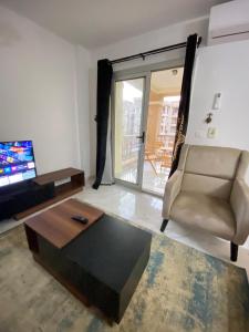 a living room with a chair and a coffee table at Central Park hotel apartment in Madinaty
