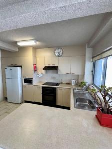 a kitchen with white appliances and a clock on the wall at Uninterrupted Ocean & Channel Views in The Entrance +4 photos