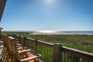 een rij strandstoelen op een houten terras bij Just One More Day Home in Bolivar Beach
