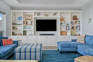 een woonkamer met twee blauwe banken en een televisie bij Just One More Day Home in Bolivar Beach