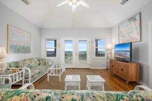 un soggiorno con un divano e una TV di Lotz A View Home a Bolivar Beach