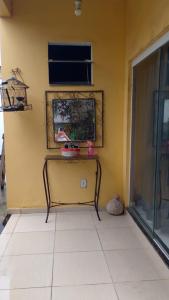 a yellow wall with a table in a room at Suíte aconchego in Cabo Frio