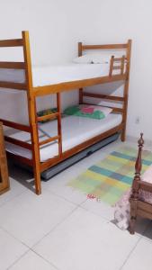 two bunk beds in a room with a rug at Suíte aconchego in Cabo Frio