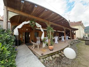 Hôtel privatisé & spa - séjour all inclusive -Adults only في Rupt-sur-Moselle: سطح خشبي مع طاولات وكراسي بيضاء