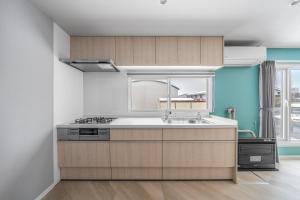 a kitchen with wooden cabinets and a sink at Villas Park Kamifurano in Kami-furano