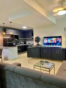 ein Wohnzimmer mit Couch und Fernseher und eine Küche in der Unterkunft Sobrado no centro da Cidade in Palmas + 17 Fotos