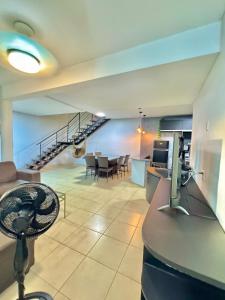 ein Wohnzimmer mit Tisch und Stühlen und einer Treppe in der Unterkunft Sobrado no centro da Cidade in Palmas