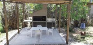 Un patio con mesa y sillas y una chimenea. en Complejo Mirando el Cerro, en Punta Colorada