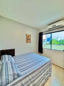 ein Schlafzimmer mit einem Bett und einem großen Fenster in der Unterkunft Sobrado no centro da Cidade in Palmas