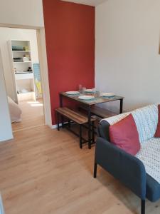 Cosy appartement calme et tout équipé idéal seul ou en couple في Seloncourt: غرفة معيشة بها طاولة وأريكة +7 صور