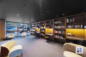 a library with a lot of bookshelves and desks at REST COLLECTION Apartments on Collins Docklands in Melbourne