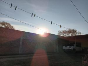 Ein Sonnenuntergang über einer Backsteinmauer, die Sonne scheint in der Unterkunft Depto en arrecifes in Arrecifes