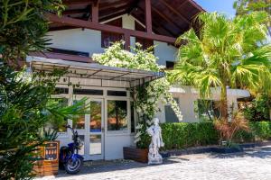 弗洛里亚诺波利斯Suítes Jurerê Internacional的前面有雕像的房子