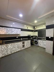 uma cozinha com azulejos pretos e brancos na parede em Carolean luxury wuye em Abuja