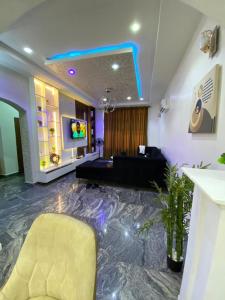 uma sala de estar com um sofá e uma TV em Carolean luxury wuye em Abuja