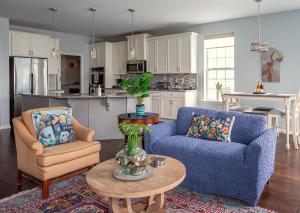 Una sala de estar con dos sillas azules y una mesa. en Azure Elephant Haven - 2 King Suites in Bayberry South, en Middletown