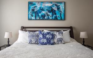 Un dormitorio con una cama con almohadas azules y blancas. en Azure Elephant Haven - 2 King Suites in Bayberry South, en Middletown 37 fotos más