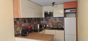 a kitchen with white cabinets and a white refrigerator at Appartement cosy a Erlach - Lac de Bienne in Erlach