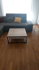 ein blaues Sofa mit Couchtisch im Wohnzimmer in der Unterkunft Charmant T3 dans résidence in Vaulx-en-Velin