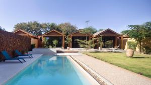 a villa with a swimming pool in front of a house at Aerys Village in Somone