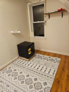 马塞纳HomeAwayFromHomeMassena的房间里，一块地毯上放着一个黑色盒子，房间里有一扇窗户。