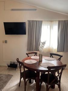 a dining room table with chairs and a television at Apartment in Merida in Mérida
