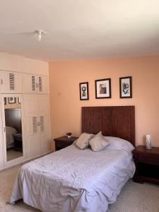 a bedroom with a large bed with three pictures on the wall at Apartment in Merida in Mérida