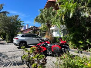 a red motorcycle parked on the side of a street at Suítes Jurerê Internacional in Florianópolis