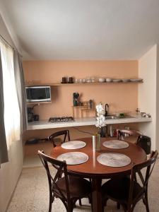 a dining room table with four chairs and a kitchen at Apartment in Merida in Mérida