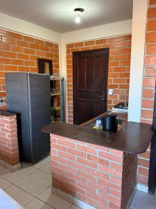 a kitchen with a brick counter and a refrigerator at Kantinho do Mar in São Francisco do Sul +3 photos