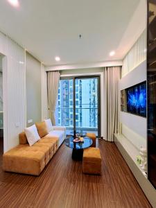 een woonkamer met een bank en een groot raam bij Sunny Residence Masteri Waterfront, Hà Nội in Gia Lâm Pho