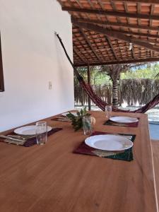 een houten tafel met borden en glazen erop bij Casa Beleza Atins in Atins +86 foto's