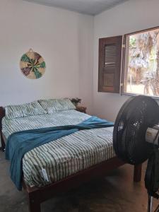 een slaapkamer met een bed en een raam bij Casa Beleza Atins in Atins