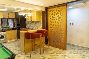 a kitchen with a table and some bar stools at Hapton apartment in Abuja