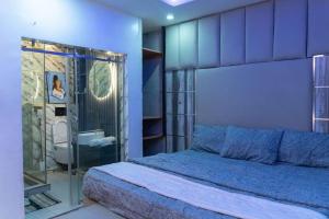 a bedroom with a bed and a glass shower at Hapton apartment in Abuja +56 photos